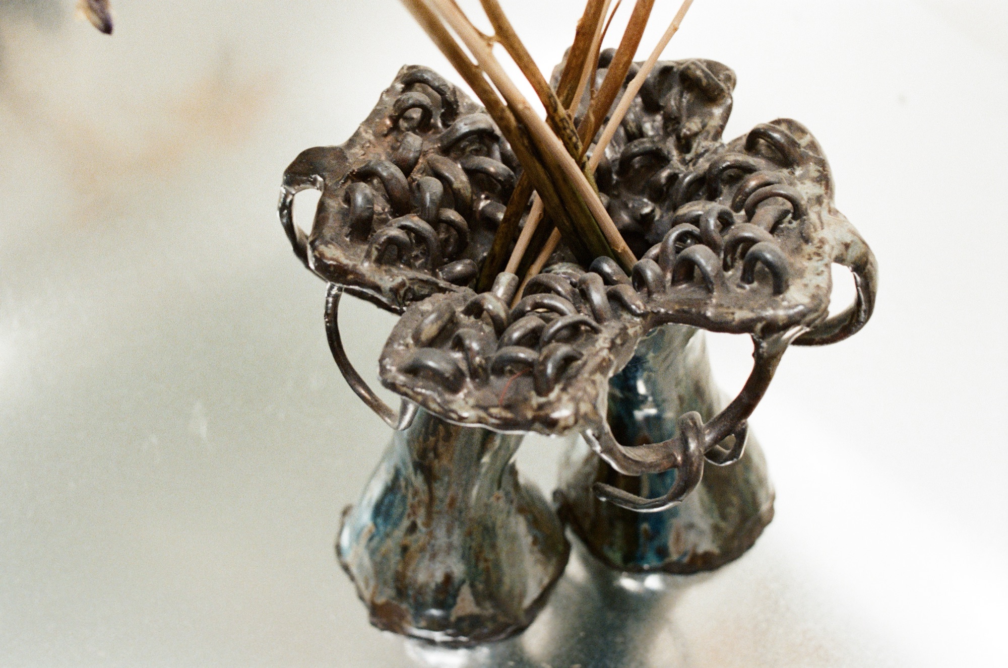 Double-spouted vessel holding dried reeds